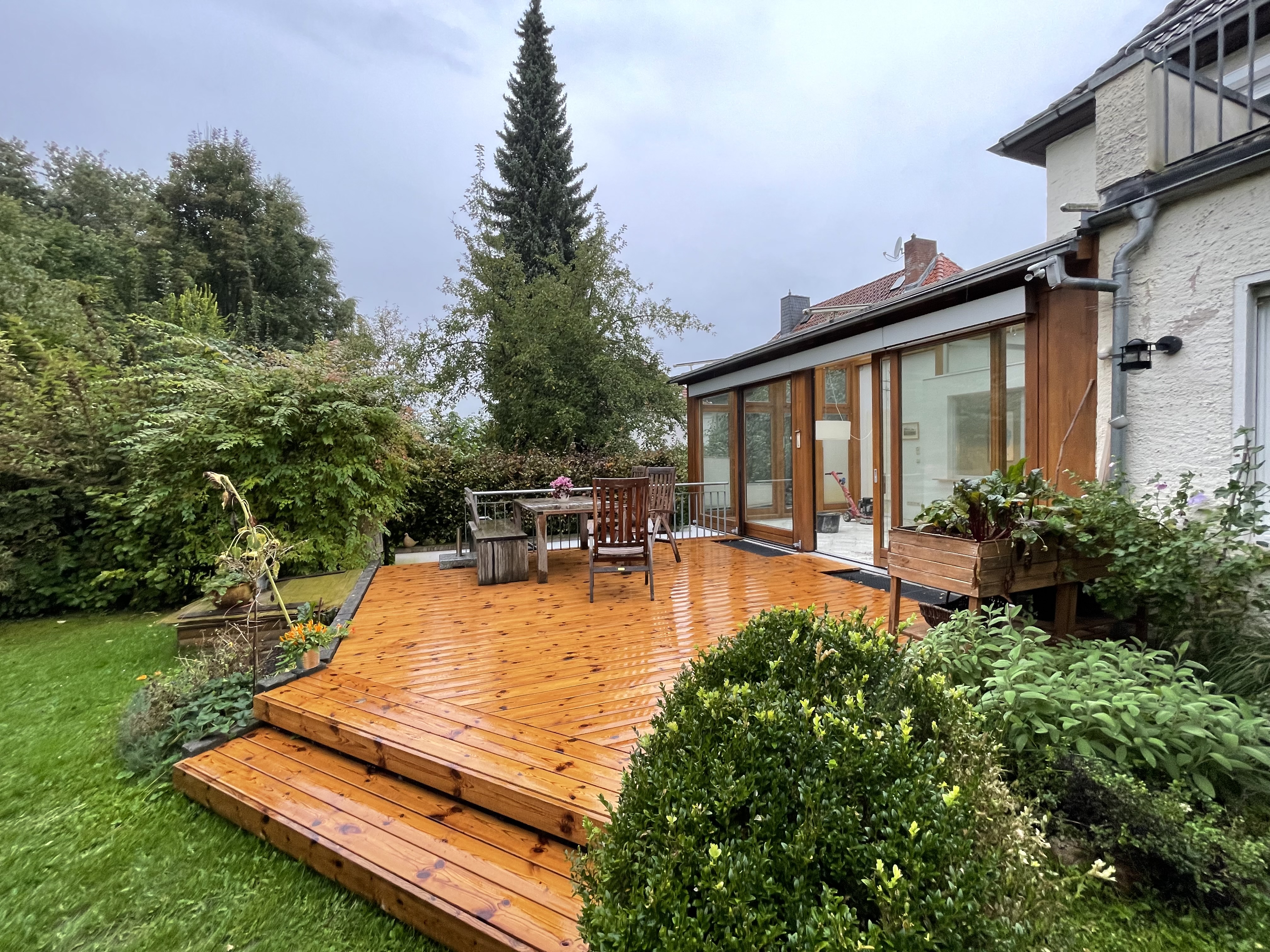 Holzterrasse aus Thermokiefer mit Grad® System vor einem Wohnhaus
