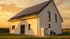 Modernes Einfamilienhaus mit Photovoltaikanlage auf dem Dach und einer Luft-Wasser-Wärmepumpe im Garten bei Sonnenuntergang.