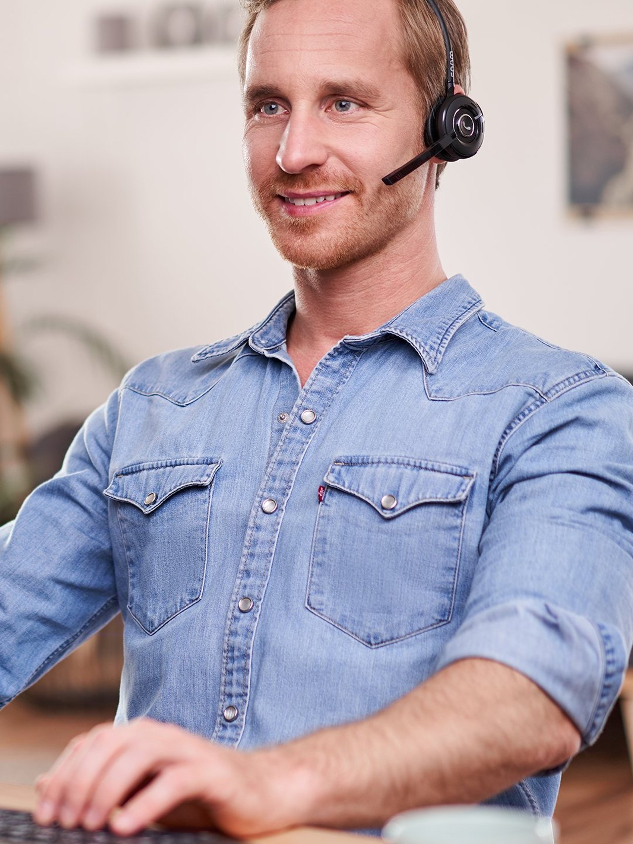 Mitarbeiter mit Headset telefoniert am Arbeitsplatz über die STARFACE App. Bild: STARFACE GmbH
