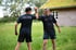 Zwei Männer in Sportkleidung geben sich im Gras die Faust, einer trägt ein T-Shirt mit der Aufschrift „Denny Dramm Personal Trainer“.