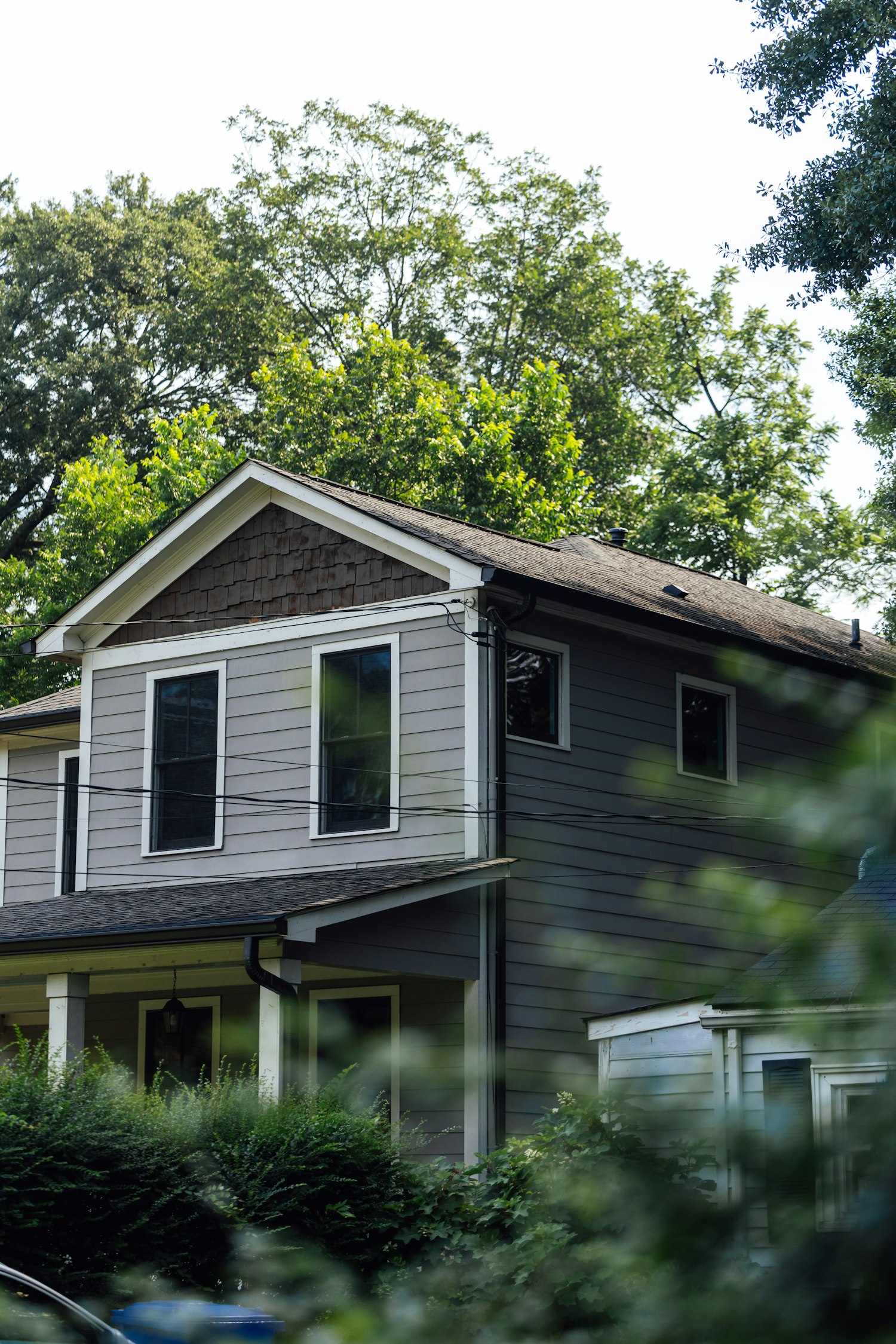 Two-storey home with a pitched roof surrounded by trees