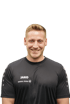 Mann mit kurzen, blonden Haaren im schwarzen JAKO-Trikot mit SIGNAL IDUNA-Logo vor weißem Hintergrund.
