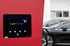 Roter Hypercharger Ladepunkt mit Display und einem schwarzen Elektroauto.