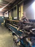 Langer Wellenrohling eingespannt auf Schwerdrehbank in Produktionshalle