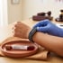 A gloved hand touches a fitness tracker on a person's wrist near a blood sample tube labeled Longevity Panel.