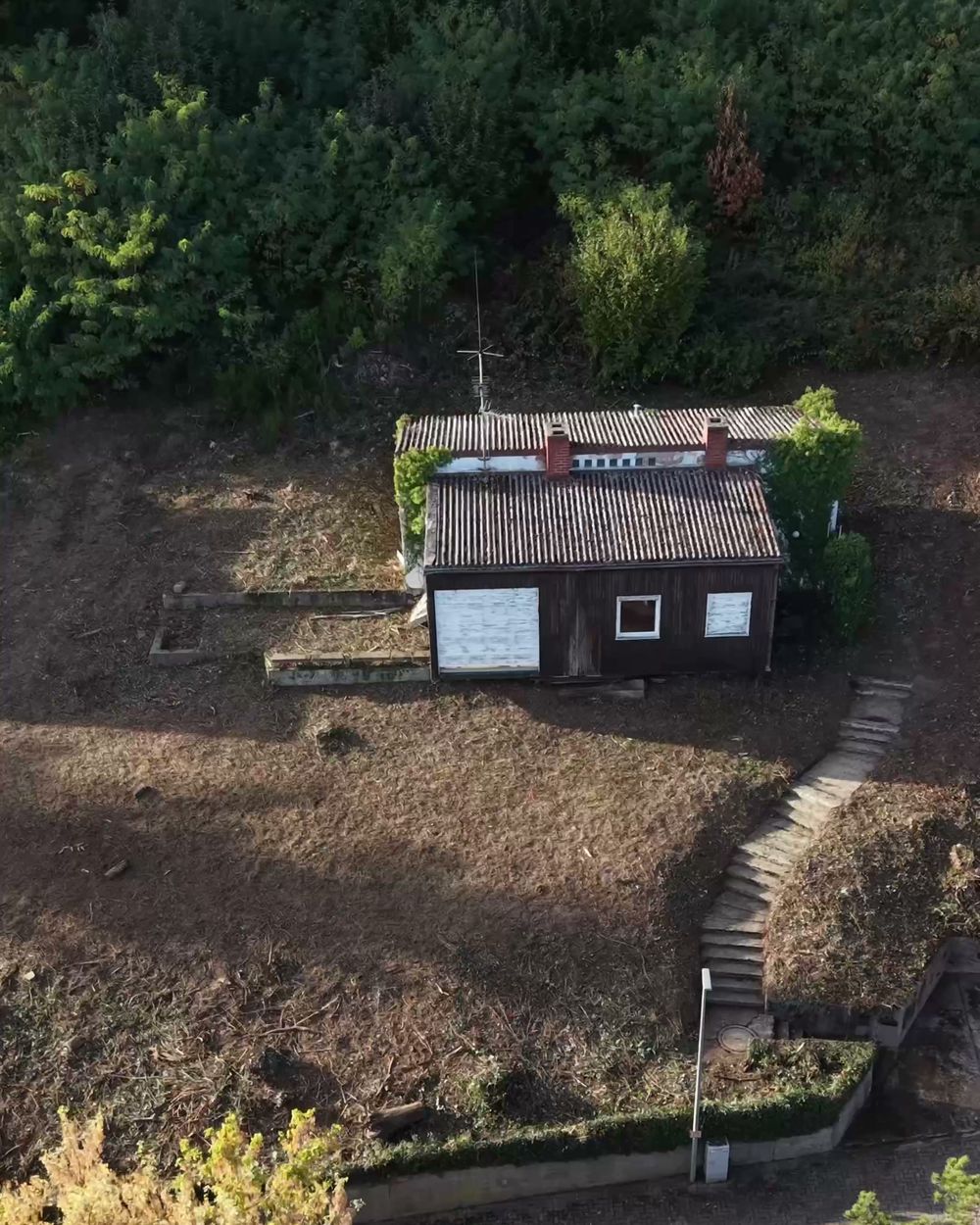 Das Grundstück in Gleiszellen nach der Rodung, von oben: freie Fläche, Treppe und Haus