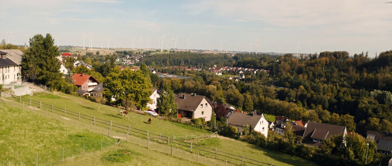 Pferdeweide am Hang über Bad Wünnenberg mit Windrädern am Horizont