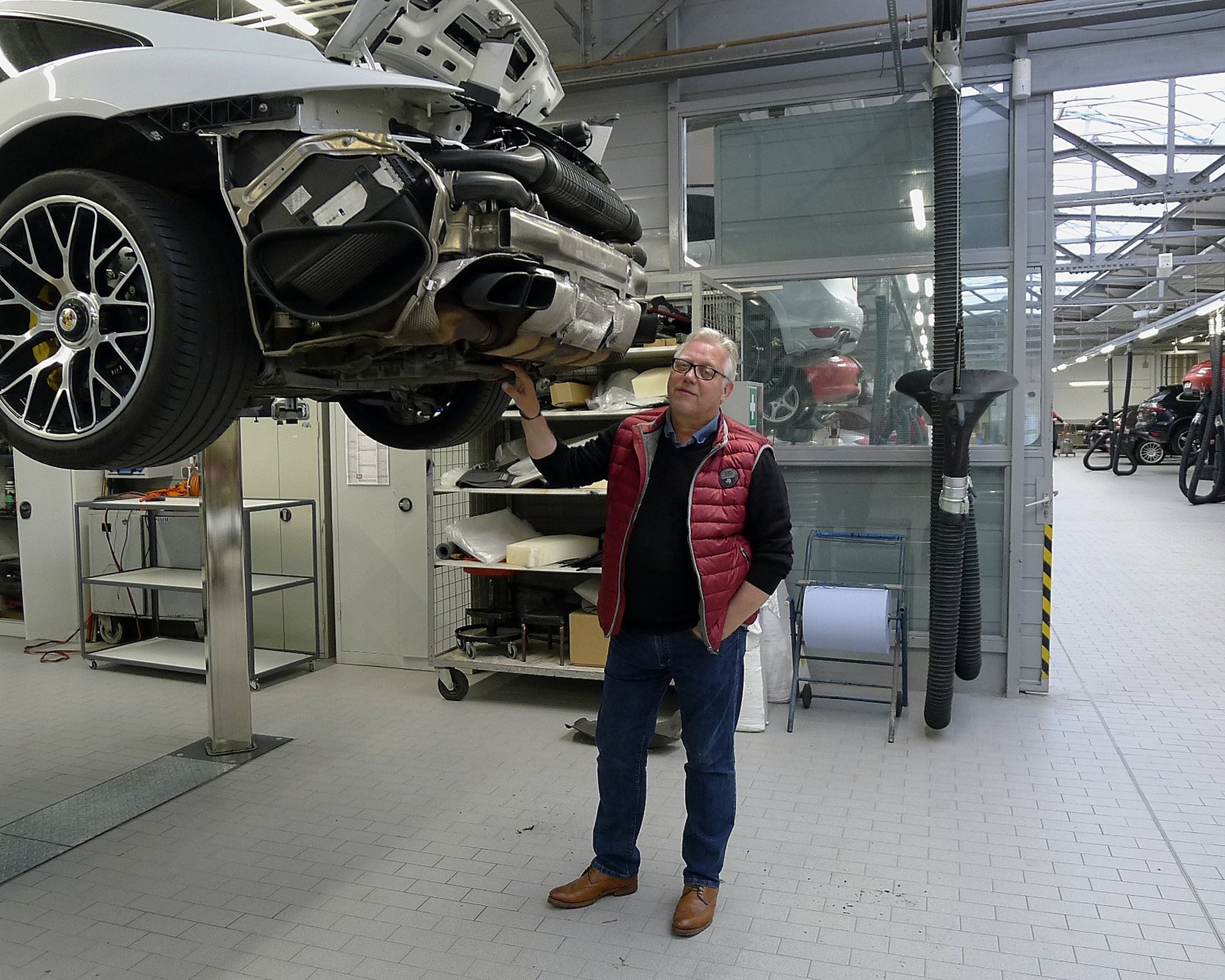Thorsten Schlieker in der Werkstatt unter einem Porsche 911 auf der Hebebühne