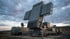 Großes militärisches Radarsystem mit flachen, rechteckigen Antennenpaneelen unter bewölktem Himmel in der Dämmerung.
