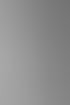 Schwarz-Weiß-Aufnahme eines Brautpaares vor Steinsäulen; der Bräutigam küsst die Braut mit Rosenstrauß auf die Wange.