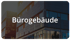 Modernes Bürogebäude mit dunkler Fassade und dem weißen Schriftzug Bürogebäude.