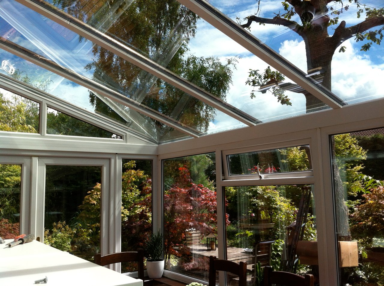 Wintergarten mit glasklaren Fensterflächen und Blick in den Garten