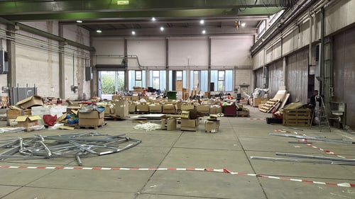 Halle mit sortierten Kartons und abgesperrtem Arbeitsbereich