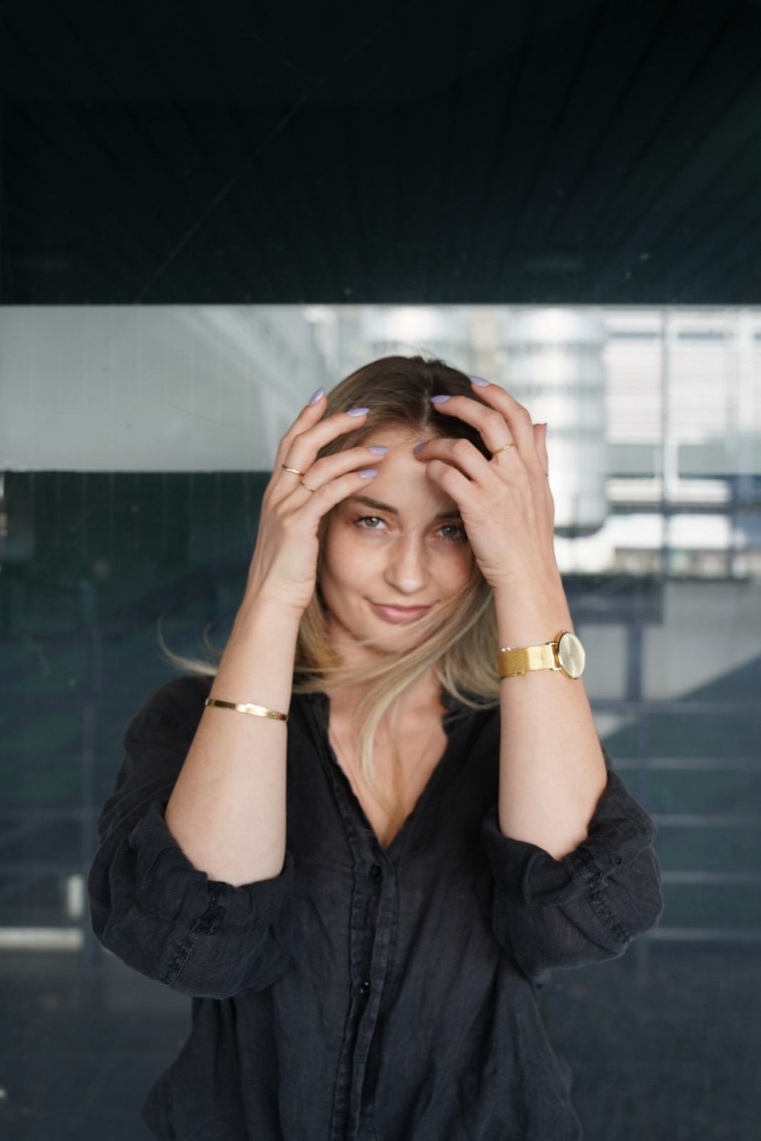 Tatjana Schäfer in schwarzer Bluse, die Hände an den Schläfen, Blick in die Kamera