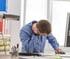 Man experiencing neck pain at his office desk
