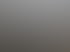Modernes Balkongeländer aus Metall und Milchglas an einer Hausfassade unter bewölktem Himmel.