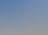 Photovoltaikanlage auf einem großen Scheunendach, im Hintergrund bewaldete Hügel und blauer Himmel.