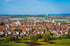 Panoramablick über Fellbach mit dem Schwabenlandtower im Hintergrund. Am Horizont sind unter blauem Himmel Wälder und Felder zu sehen.
