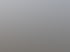 Große, leere Metallregale im Freien auf einem betonierten Gelände unter grauem Himmel.