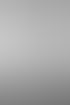 Schwarz-Weiß-Aufnahme einer Frau von hinten in weißer Spitzenunterwäsche und einem langen, transparenten Brautschleier.