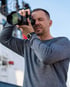 Tommy Döscher beim Fotografieren mit einer Kamera am Auge.