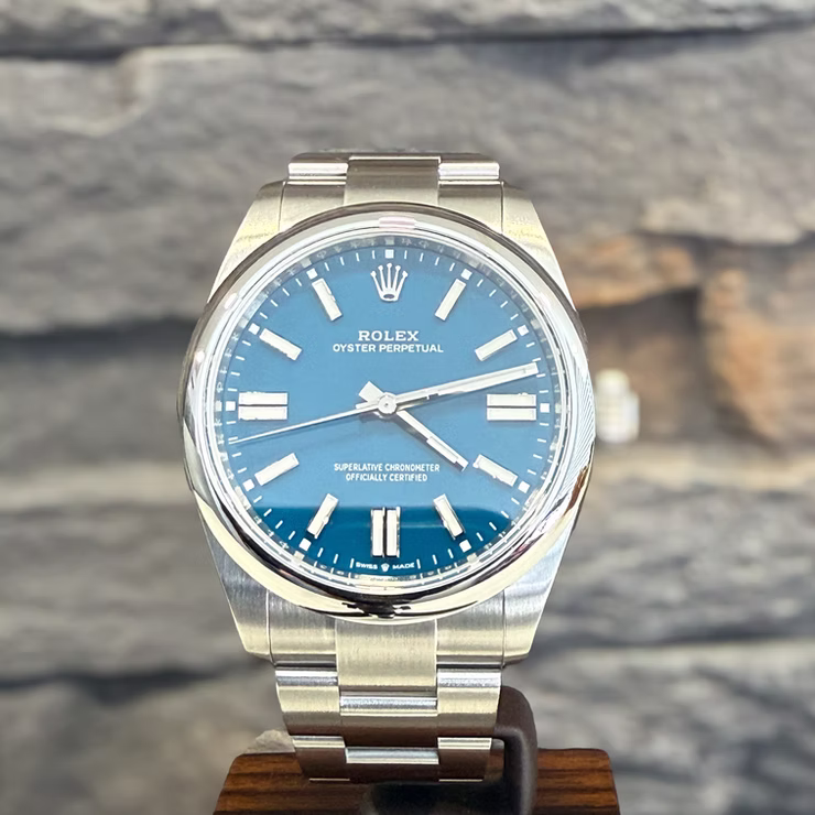 Nahaufnahme einer silbernen Rolex Oyster Perpetual Uhr mit blauem Zifferblatt und silbernen Zeigern.