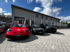 Drei Porsche Fahrzeuge in Rot, Schwarz und Schwarz auf einem Hof der Automobile Just UG stehend.