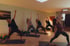 Fünf Frauen praktizieren Yoga in der Krieger-Pose auf Matten in einem hellen Studio.