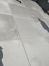 Großformatige hellgraue Terrassenplatten in Betonoptik mit schmalen Fugen im Außenbereich.