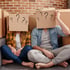 Two people with cardboard boxes on their heads representing brain fog.