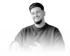 Ein lächelnder Mann mit Bart und dunklem Pullover, mit einem Mikrofon an der Brust.