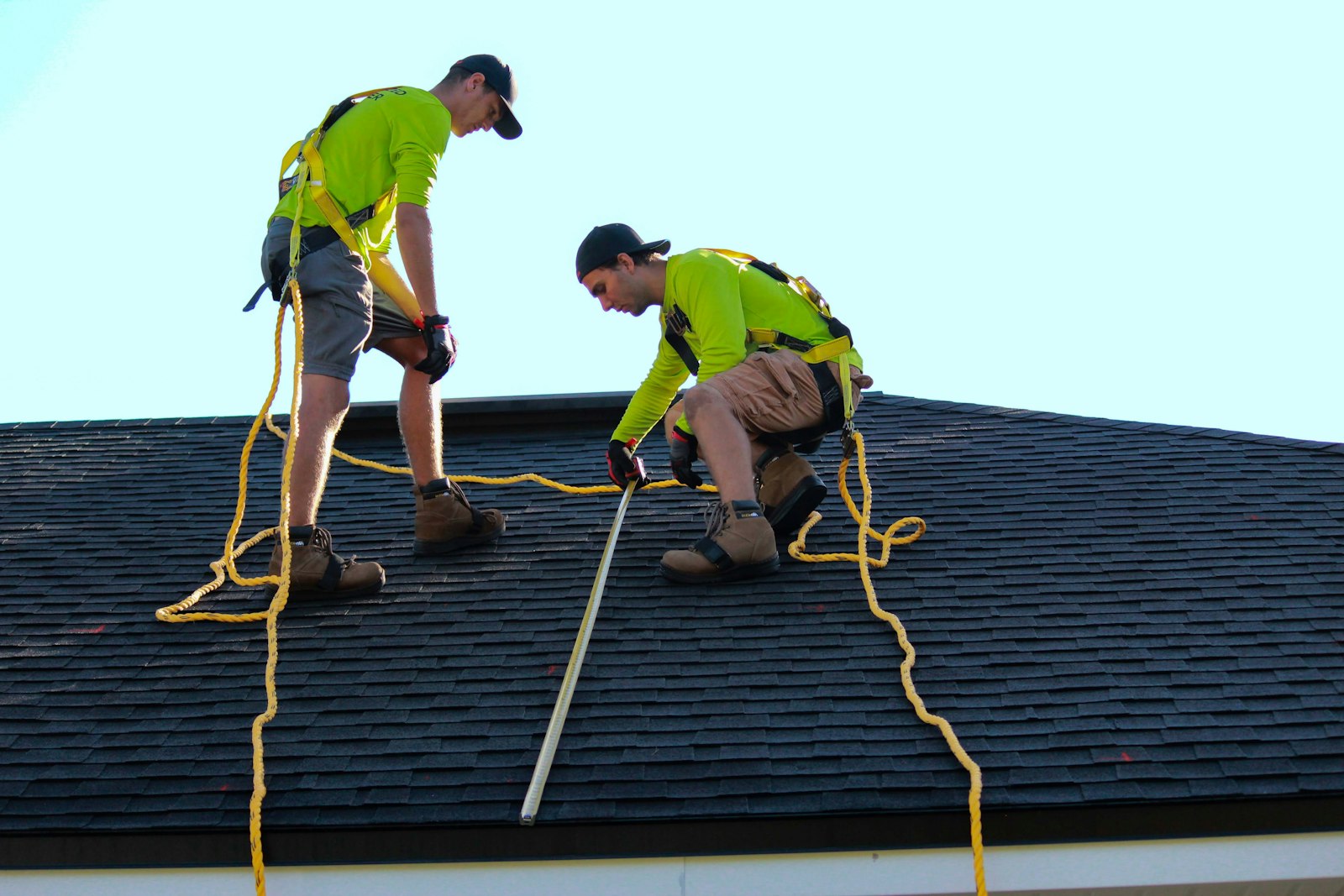 Two roofers working together on a residential roof