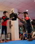 Ein Kind in Rot und ein Mann in Schwarz mit Boxhandschuhen trainieren im Boxstudio.
