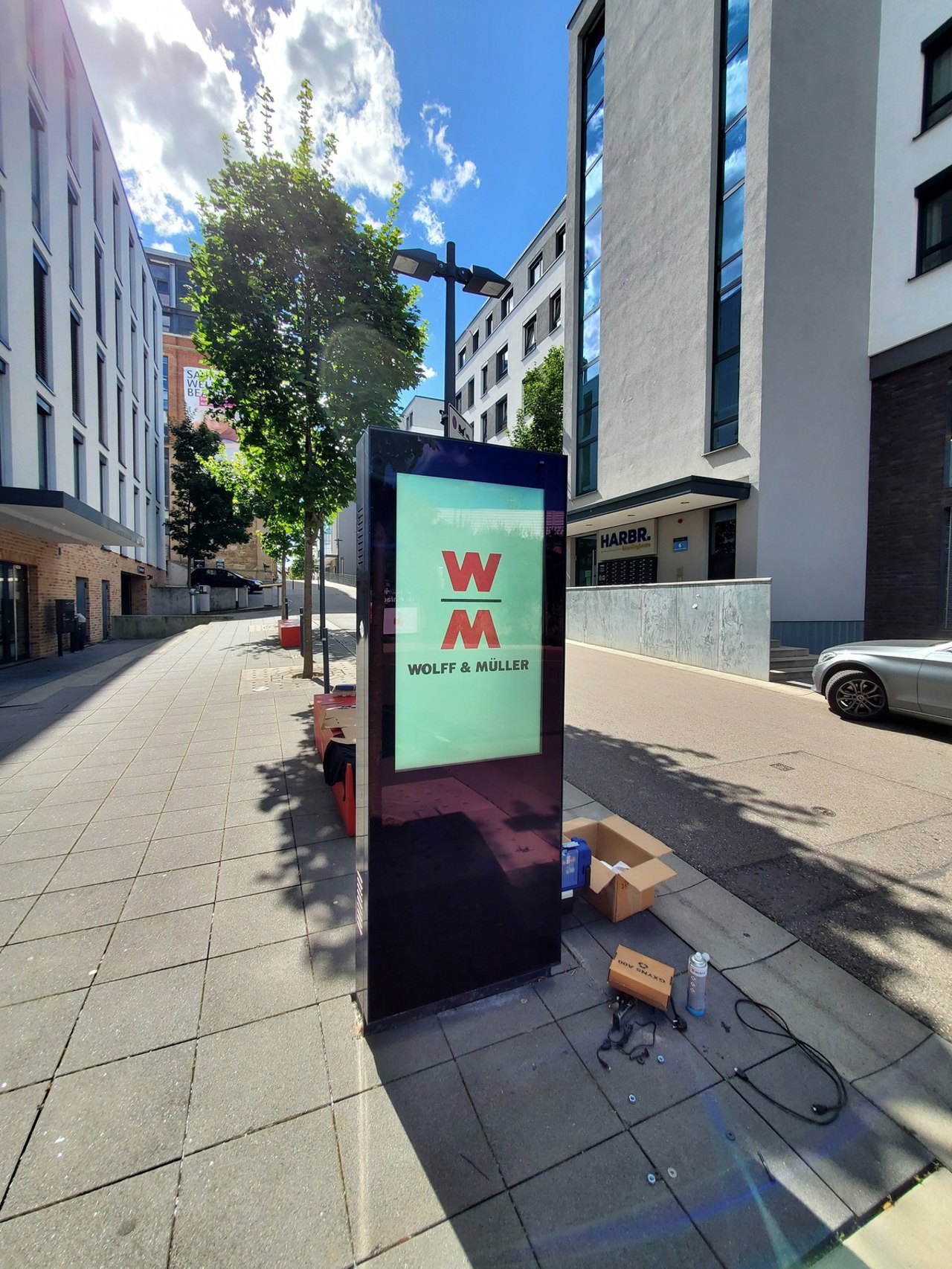 Freistehende WinScreen CITY Info-Stele im Hochformat an einem Eingangsbereich