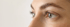 Nahaufnahme eines Auges mit betonten Wimpern und einer präzise geformten, gelifteten Augenbraue.