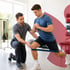 Regenerative sports medicine therapist assists patient doing banded lunges.