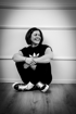 Martina Yazgan, die Gründerin von The Inner Markteer, ist im sportlichen Outfit sitzend auf dem Boden mit einem sehr lockeren Lächeln und Sitzstil abgelichtet. Sie drückt aus: Ruhe, Zufriedenheit, Stärke, Peace.