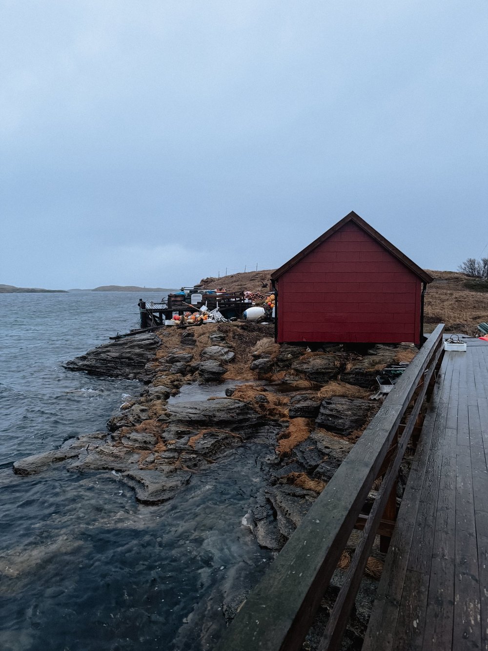 Rotes Bootshaus am Felsufer