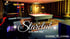 Ein Billardtisch in einem dunklen Raum mit Teppich, Bar und Spielgeräten; Text: „Starclub Live – Bühne – Bar“.