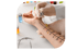 Eine Person mit Handschuhen trägt Tropfen auf den Arm einer anderen Person für einen Allergietest auf.