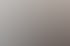Drei lächelnde Büroangestellte stehen nebeneinander vor einem Aktenregal und einem Schreibtisch im hellen Büro.