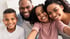 Eine lächelnde afroamerikanische Familie mit zwei Kindern macht ein Selfie-Porträt.