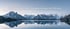 Schneebedeckte Berge spiegeln sich in einem ruhigen See unter dem Text "Erfolg verpflichtet: Verantwortung als Privileg."