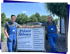 Jonas und Joachim in blauer Arbeitskleidung stehen neben einem Firmenschild von Pelzer & Althues Metallbau in Oelde.