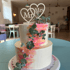 Zweistöckige Hochzeitstorte mit weißem Zuckerguss, rosa/orangefarbenen Streifen, Perlen, Eukalyptus und "Mr & Mrs" Topper.