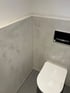 Designböden und Spachtelwände in hellgrau in einem modernen WC