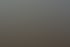 Ein einzelner kahler Baum auf einem frostigen Feld bei Sonnenaufgang mit Nebel und großen Wolken am Himmel.