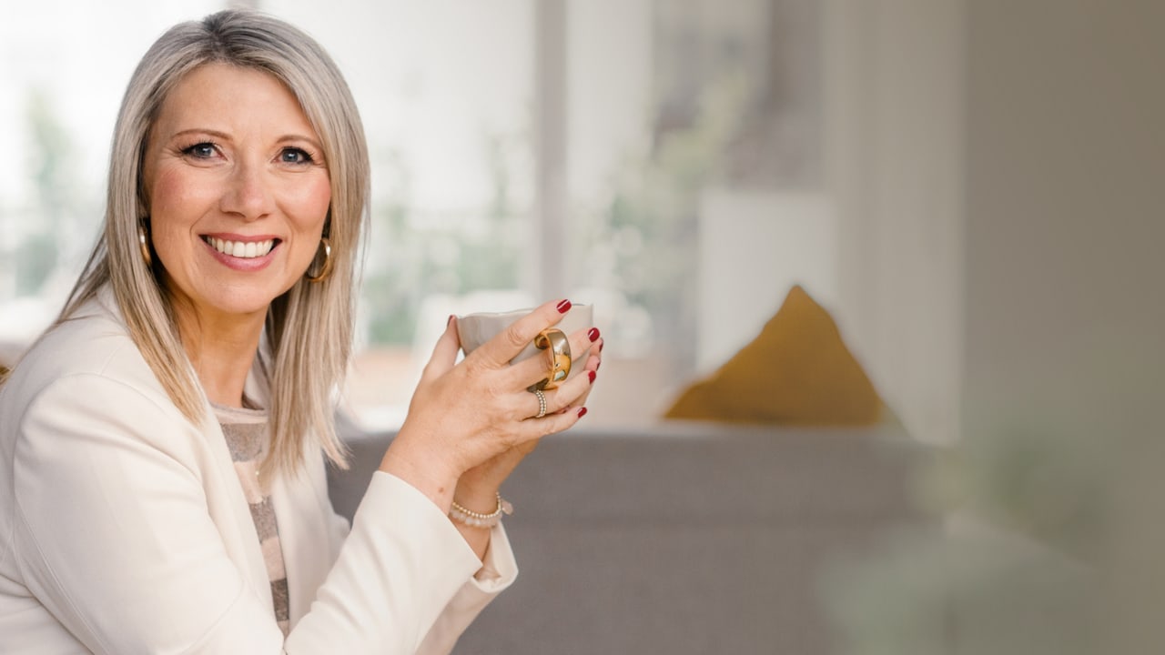 Susanne Kettler lächelnd mit einer Tasse in der Hand