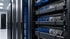 Nahaufnahme von blauen und weißen Netzwerkkabeln, die in Server-Racks in einem Rechenzentrum angeschlossen sind.