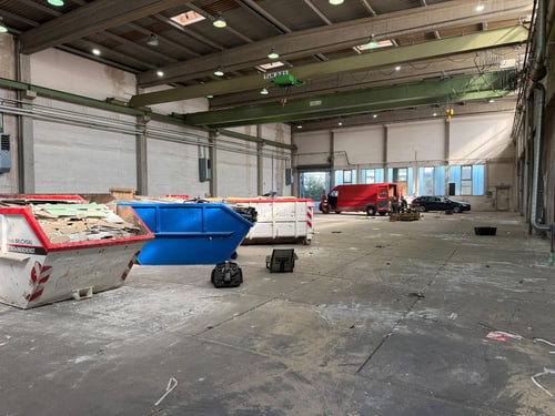 Gewerbehalle mit Containern und Transporter während der Entrümpelung